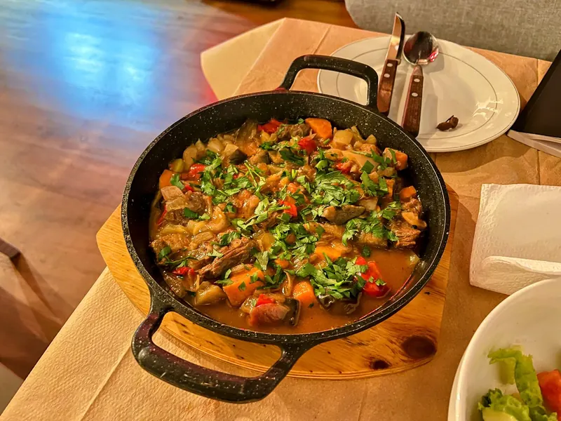Skillet of stewed meat and vegetables with peppers and fresh parsley